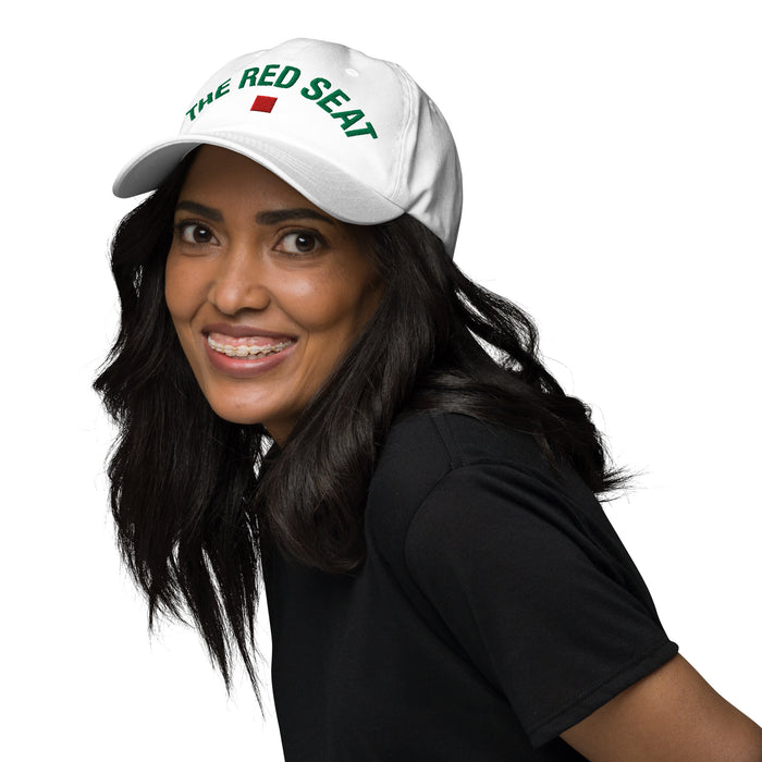 Woman wearing a white cap with 'The Red Seat' logo on a white background