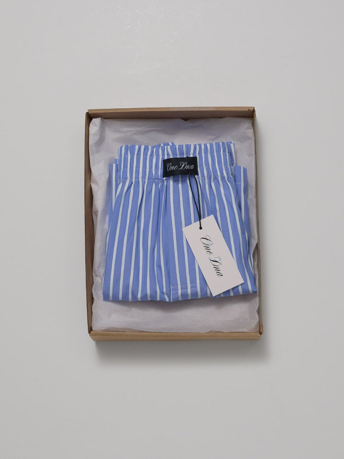 One Dna brand striped shorts, folded in am open box with tissue paper