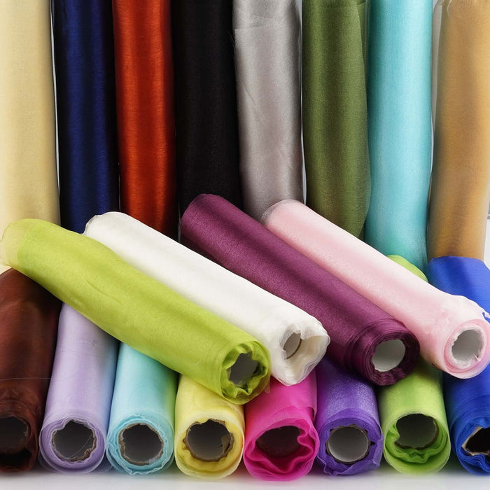 Colorful rolls of fabric stacked together in various shades and textures.